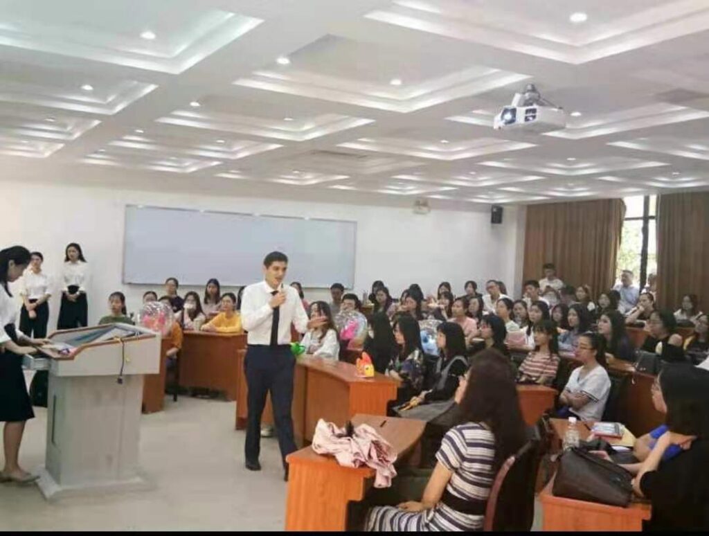 Andrew Lara can be seen presenting to an entire room of Chinese students. 