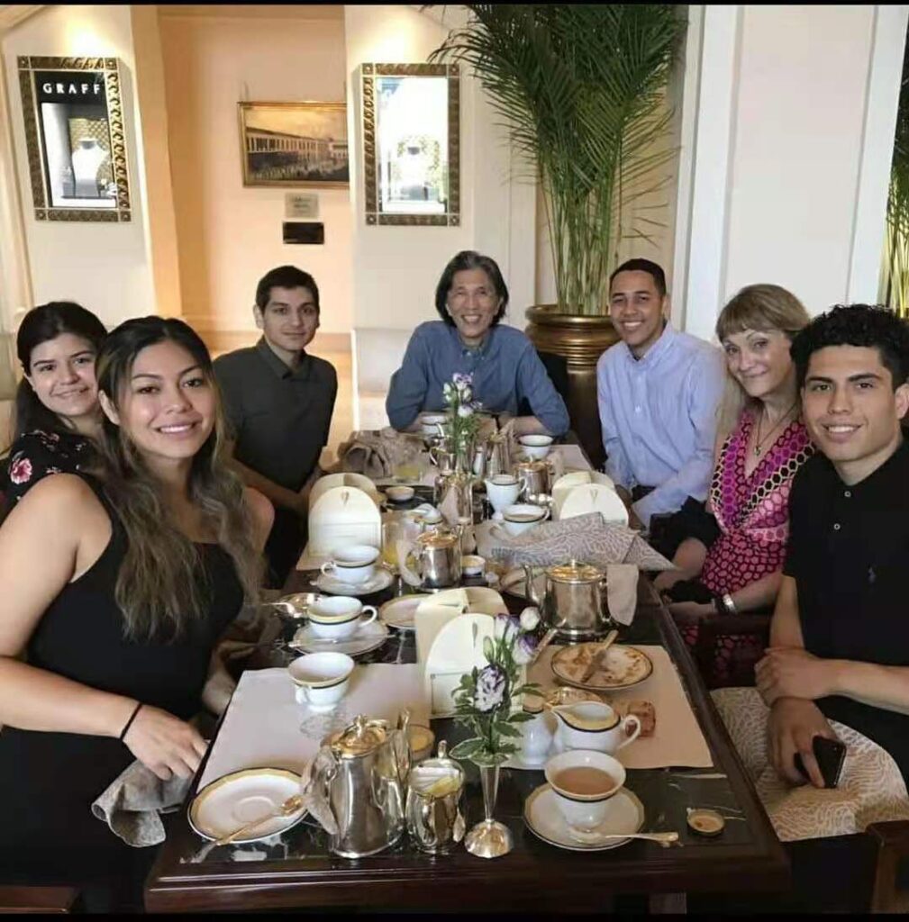 Andrew Lara is pictured at a dining table having tea and refreshments with some friends and colleagues 