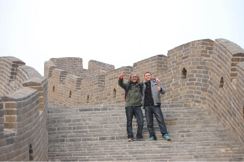 VIcente with a friend on his travels around China. They are pictured standing on a wall. 
