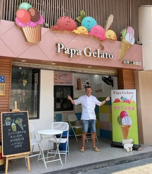 Andre poses happy in front of his ice-cream store Papa Gelato in Xiamen.